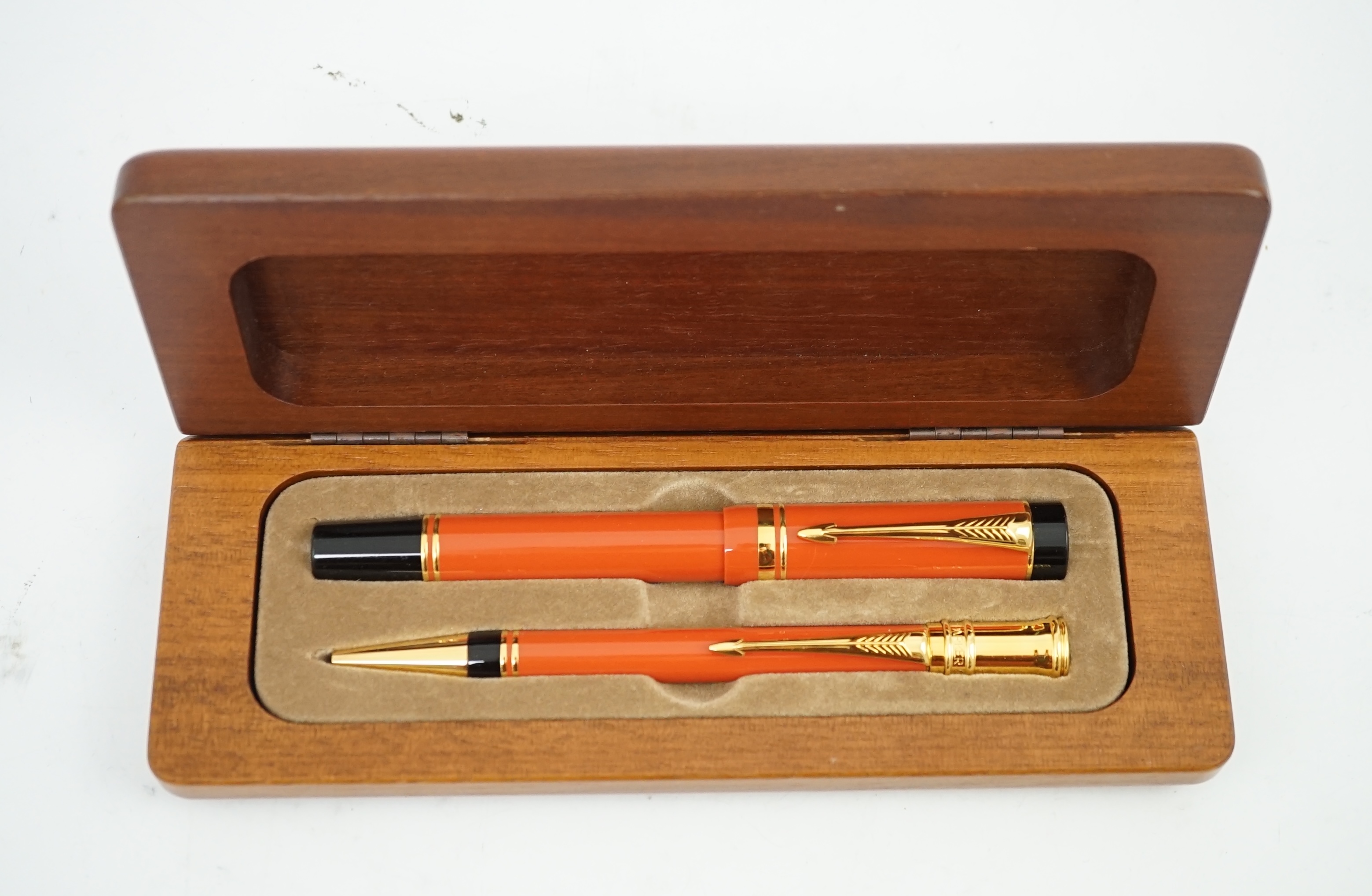 A Parker Duofold orange centennial fountain pen and pencil set, in wooden case